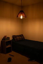 Dimly lit bedroom with a bed, nightstand, and hanging MDF light fixture.