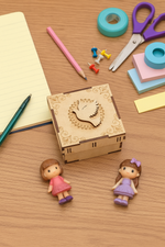 MDF decorative bird box with cut-out design on a wooden surface with stationery items.
