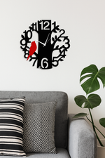 Decorative wall clock with a red bird design on a white wall above a gray sofa.