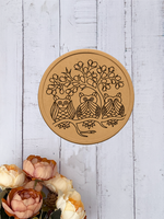 MDF Wall Plate with owl design on a light wooden surface with flowers.