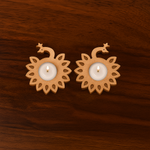 Set of two peacock-shaped MDF tea light holders with lit candles, placed on a wooden surface, ideal for Diwali, pooja, and festive home decoration.