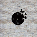 Black butterfly wall clock with a circular design and butterfly accents, mounted on a white textured brick wall, combining elegance and functionality for home decor.