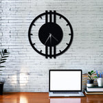Modern black wall clock with minimalist design displayed on a white brick wall above a workspace.