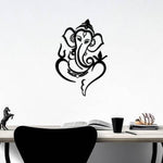 Black Lord Ganesha wall art featuring an intricate design of Ganesha’s face with symbolic elements, mounted on a white wall above a minimalist desk.