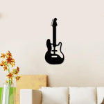 Black guitar-shaped musical wall art mounted on a beige wall above a white sofa with floral decor accents