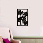 Black wall decor featuring a vertical arrangement of a bunch of flowers, mounted on a neutral-colored wall in a cozy interior setting.
