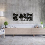 Modern living room wall decor featuring a set of three black floral frames arranged on a concrete-textured wall above a sleek wooden console table