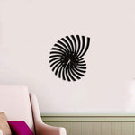 Black spiral-shaped wall clock made of MDF with a unique modern design, mounted on a neutral wall above a stylish living room setting