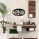Black jungle wall decor featuring a silhouette of trees and deer in an oval design, mounted on a wall above a modern wooden vanity in a bathroom.
