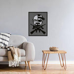 Black gangster wall art featuring a split-face design of a man with sunglasses, hat, and crossed guns, mounted on a gray wall in a modern living room.