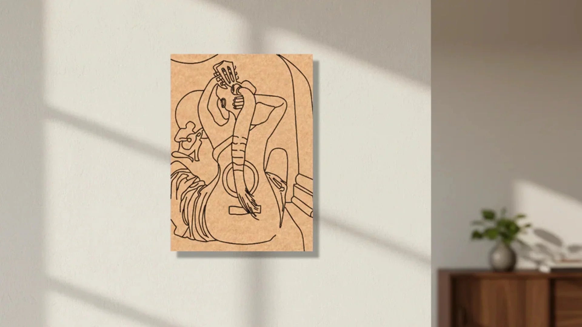 Minimalist handmade MDF wall art featuring a line-art woman playing a guitar, displayed on a modern neutral wall with soft natural sunlight.