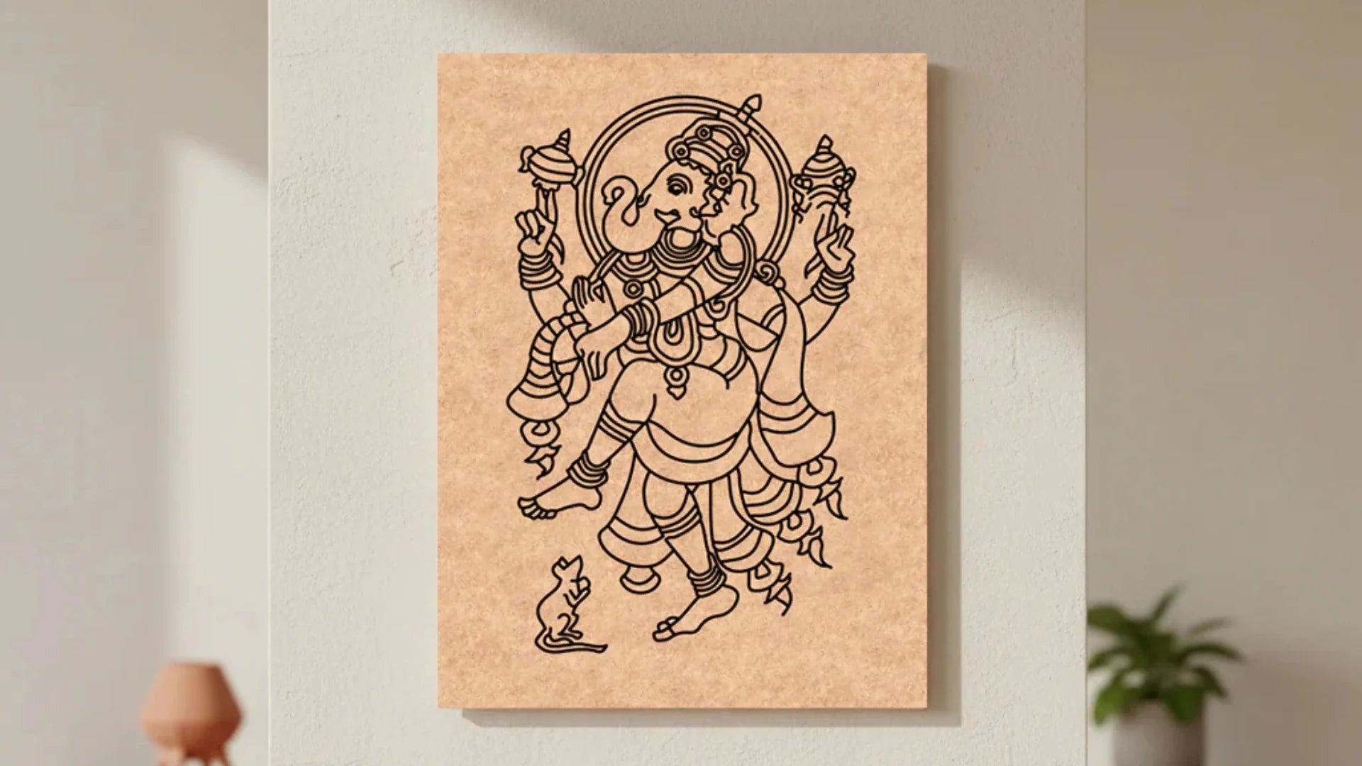 Unpainted MDF Ganesha craft base with detailed black outline artwork mounted on a neutral wall for DIY painting and traditional art projects.