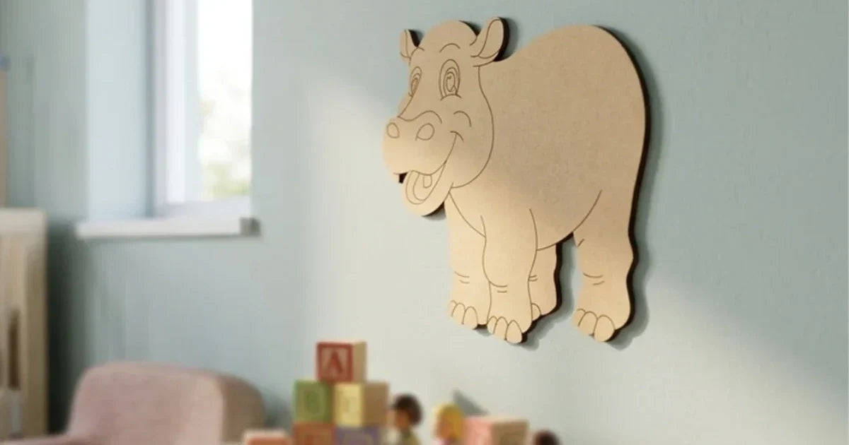 Unpainted laser-cut MDF hippopotamus wall décor with engraved cartoon details, displayed on a soft pastel nursery wall with children’s toys blurred in the background.