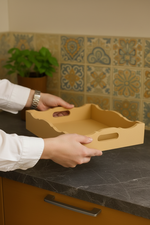 DIY scalloped MDF serving tray with handles on countertop in hand