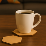 White ceramic coffee cup placed on a hexagonal MDF coaster with another coaster beside it on a wooden table.