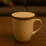 Beige ceramic mug with a round MDF coaster placed on top as a lid, sitting on a wooden table.