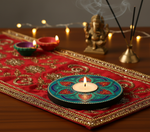 Decorative candle on a red cloth with incense sticks and a statue in the background with handpainted mdf tealight candle holder.