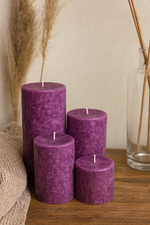 Set of purple candles on a wooden surface with a neutral background