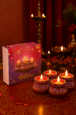 Decorative matka candle diya with a matching box on a patterned surface.