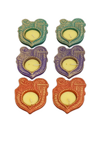 Shri‑shaped decorative diya candles arranged in colorful set for festive décor