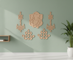 Decorative MDF DIY wall art pieces on a light green wall with a plant in the corner.