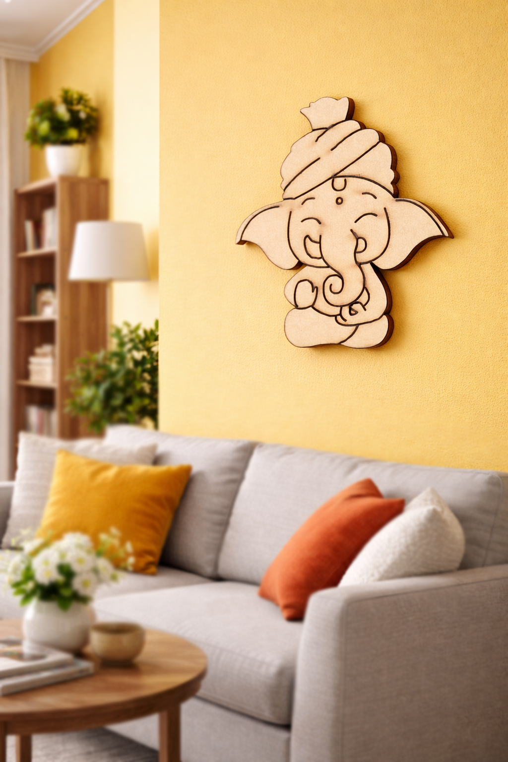 Living room with a gray sofa, colorful pillows, and a  MDF DIY  wall decor of an ganesh head on a yellow wall.