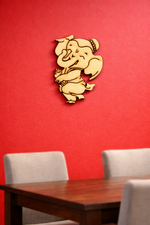 MDF DIY wall decor of a ganesh on a red wall above a wooden table with chairs.