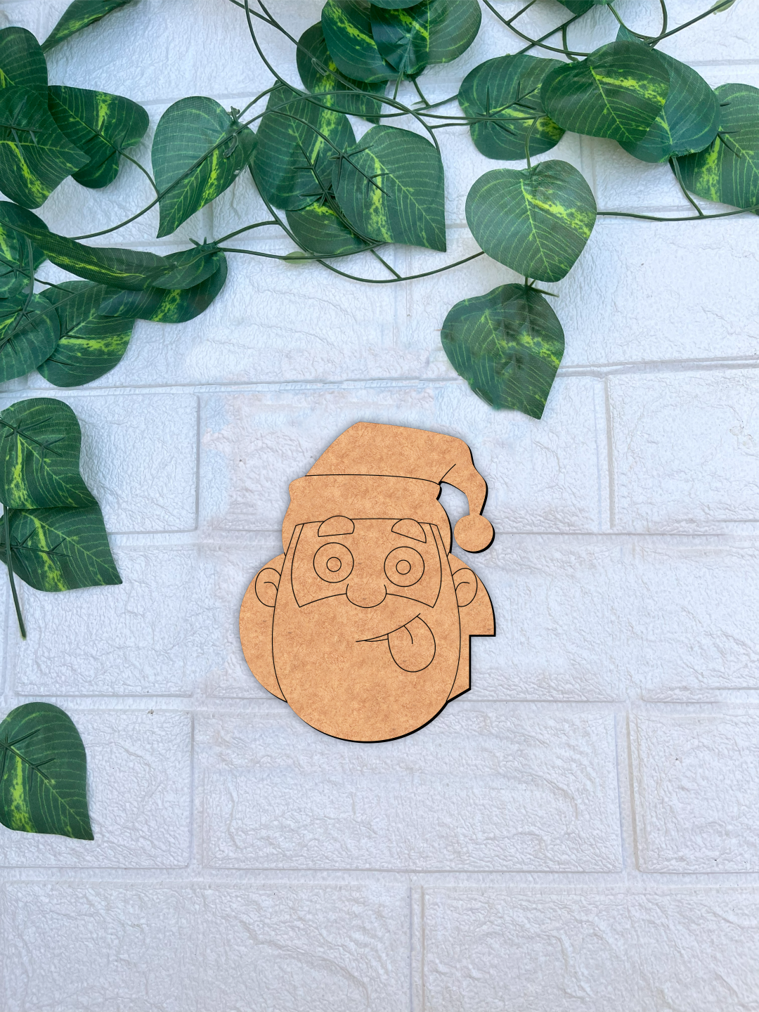 Unpainted MDF Santa face DIY cutout for Christmas craft mounted on a white textured brick wall