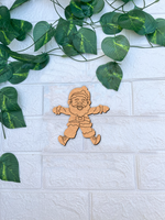 DIY MDF Santa Claus cutout for Christmas craft and painting mounted on a white textured brick wall