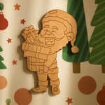 DIY MDF Santa holding gift box cutout blank for painting, Christmas craft decoration and festive decor mounted on Christmas decorated wall