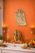 Decorative MDF DIY  wall art of a deity on an orange wall with statues and offerings below.