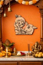 Decorative  MDF DIY wall art of a child with a lamb on an orange wall with religious items below.
