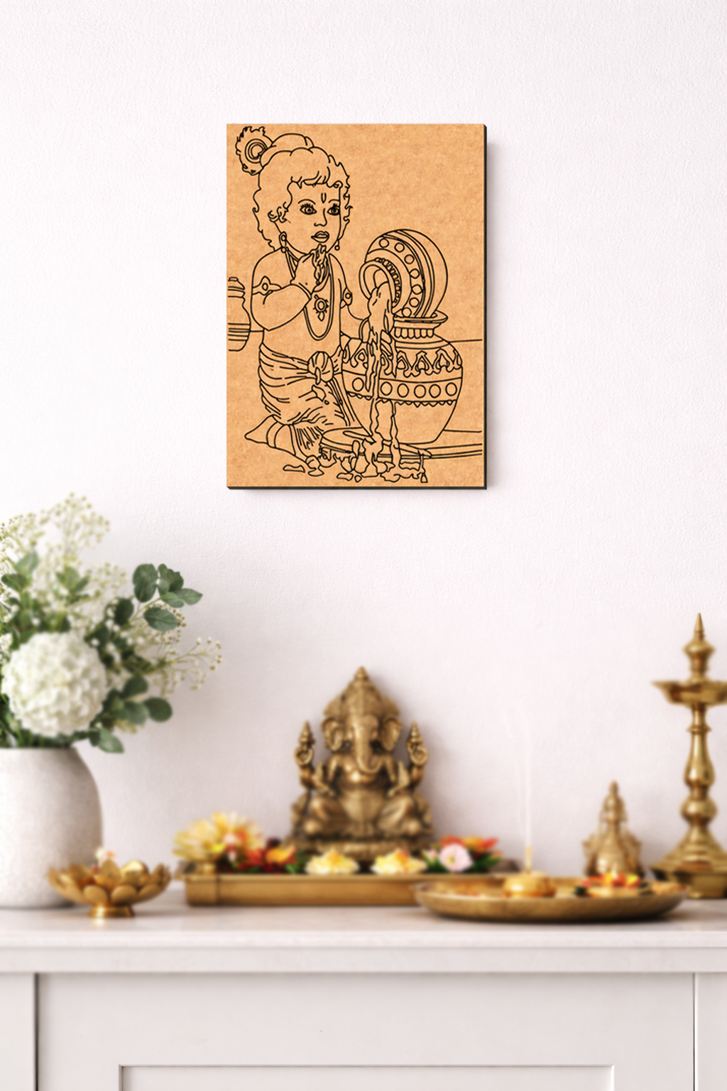 Decorative MDF DIY wall art of a child with a pot on a white wall above a table with religious items.