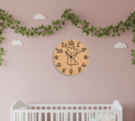 MDF DIY clock with a cat design on a pink wall with green vines and white clouds.