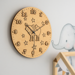 DIY MDF wall clock with space-themed design on a light gray wall.