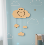 MDF DIY cloud-shaped clock with hanging clouds on a light blue wall with cloud patterns.