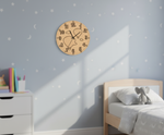 MDF DIY wall clock on a wall with a child's bed and toys in the background