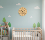 MDF DIY wall clock with 'Tomek' branding in a child's bedroom with crib and toys.