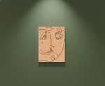 Abstract line art of a face on a beige card against a green wall