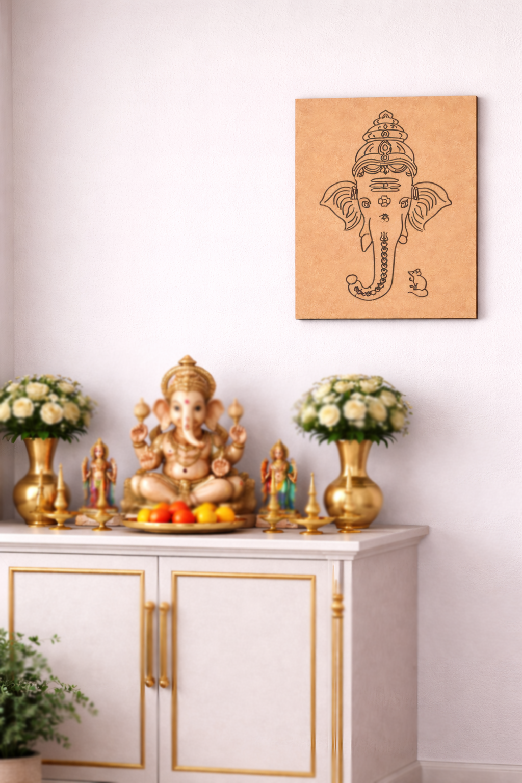 Decorative setup with a statue of Ganesha, flowers, and a MDF DIY wall art piece on a white wall.