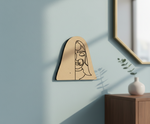 MDF DIY  wall art with a minimalist face design on a light blue wall.