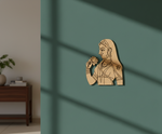 MDF DIY decorative wall piece of a woman holding a flower on a green wall.