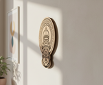 Decorative MDF DIY wall art piece on a light gray wall with a plant to the left.