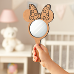 Black-painted Minnie bow mirror with red bow placed upright in a holder.