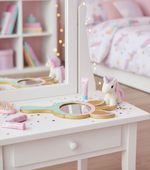 Decorated unicorn mirror placed on a kids’ vanity table with toys and accessories