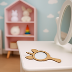 Plain unicorn MDF mirror lying on a white table in a pastel kids’ room.