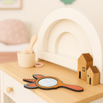 Painted unicorn MDF mirror placed on a wooden dresser with wooden toy houses.
