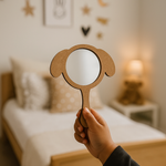 Hand holding a dog-ear shaped MDF mirror in a cozy bedroom