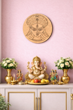 Decorative  DIY MDF Durga  wall art of a face on a pink wall with a small altar featuring a statue and flowers.