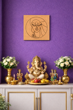 Decorative setup with a statue of Ganesha, flowers, and a MDF DIY framed artwork on a purple wall.